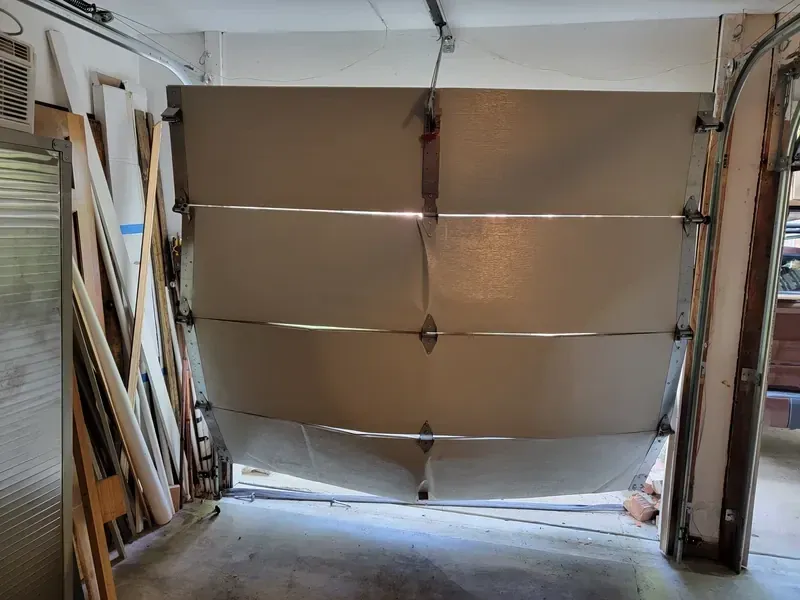 Garage door off its track being repaired